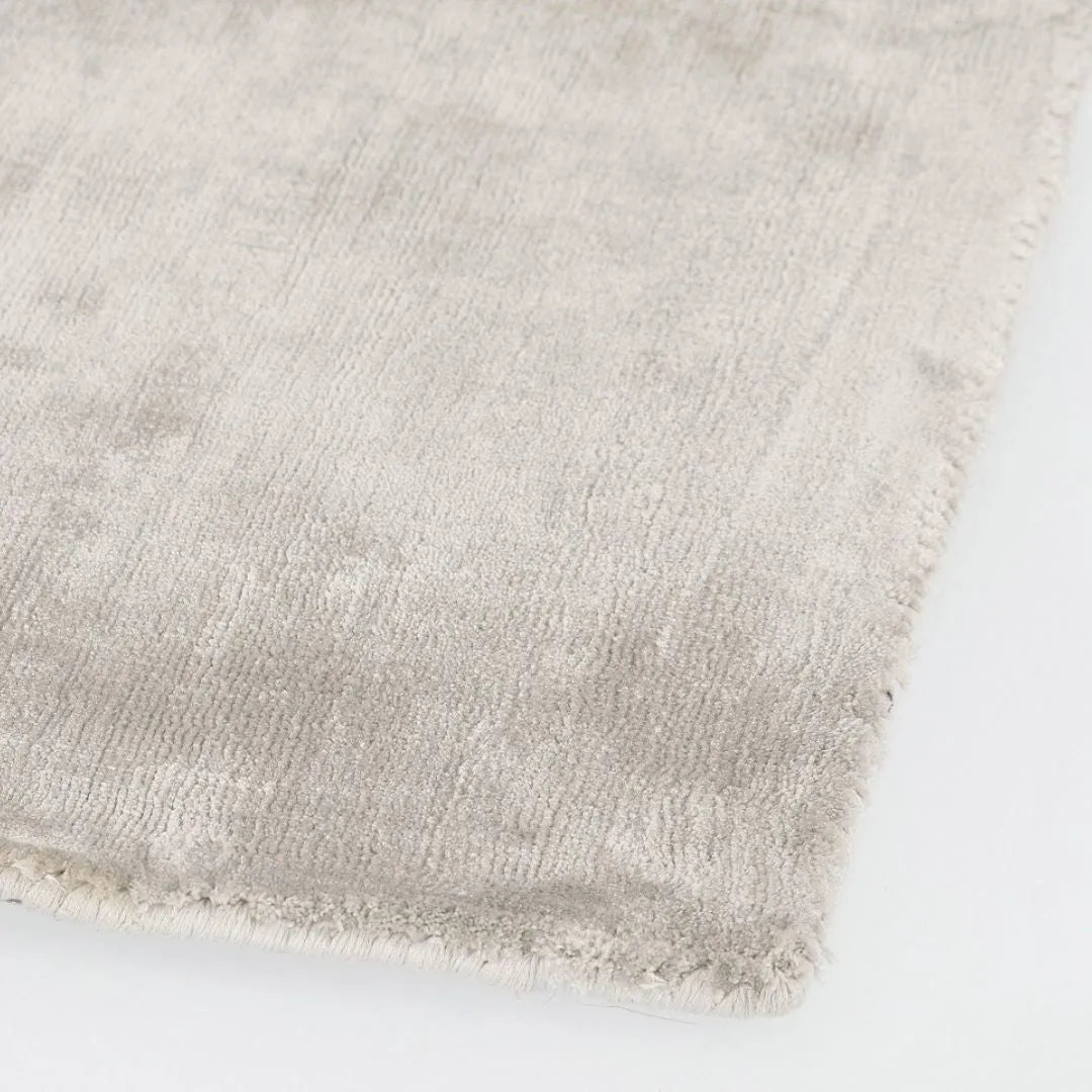 Primo piano dell’angolo del tappeto tortora con superficie vellutata

