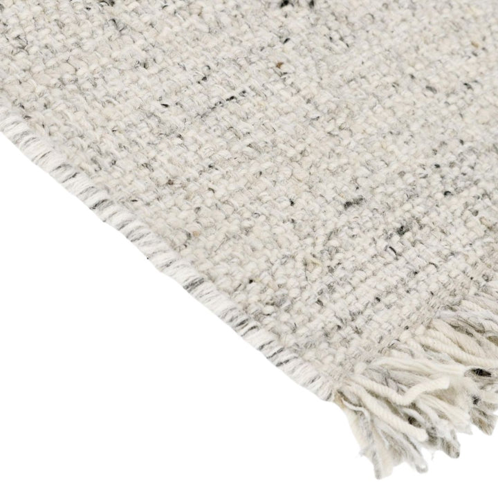 Primo piano della tessitura intrecciata del tappeto Sahana beige con frange