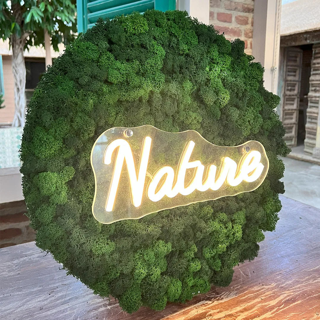 Quadro decorativo con muschio stabilizzato e scritta luminosa in ambiente moderno