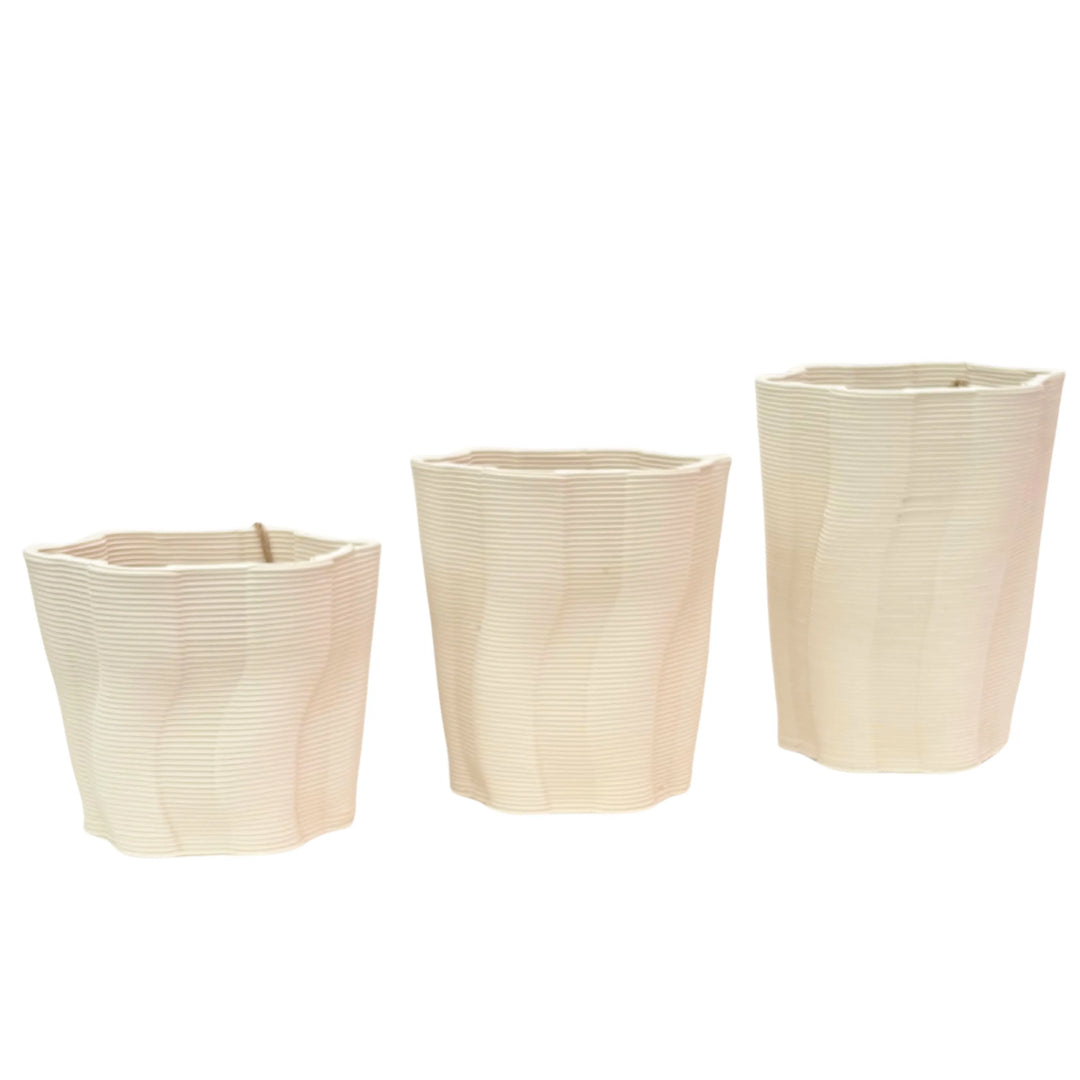 Vista frontale del set di vasi venezia ovali di colore bianchi con 
texture rigata 