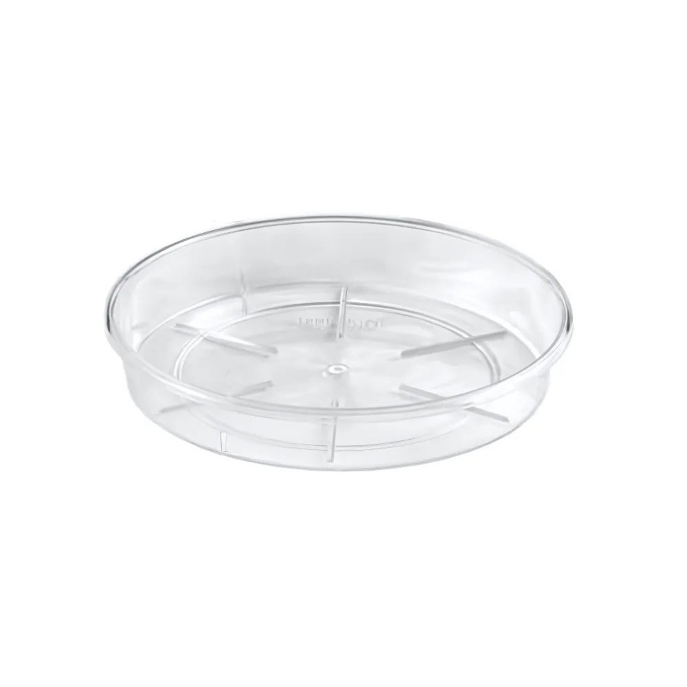 Sottovaso rotondo trasparente in plastica rigida, con base rialzata e scanalature interne per favorire il drenaggio dell'acqua. Ideale per vasi da interno.