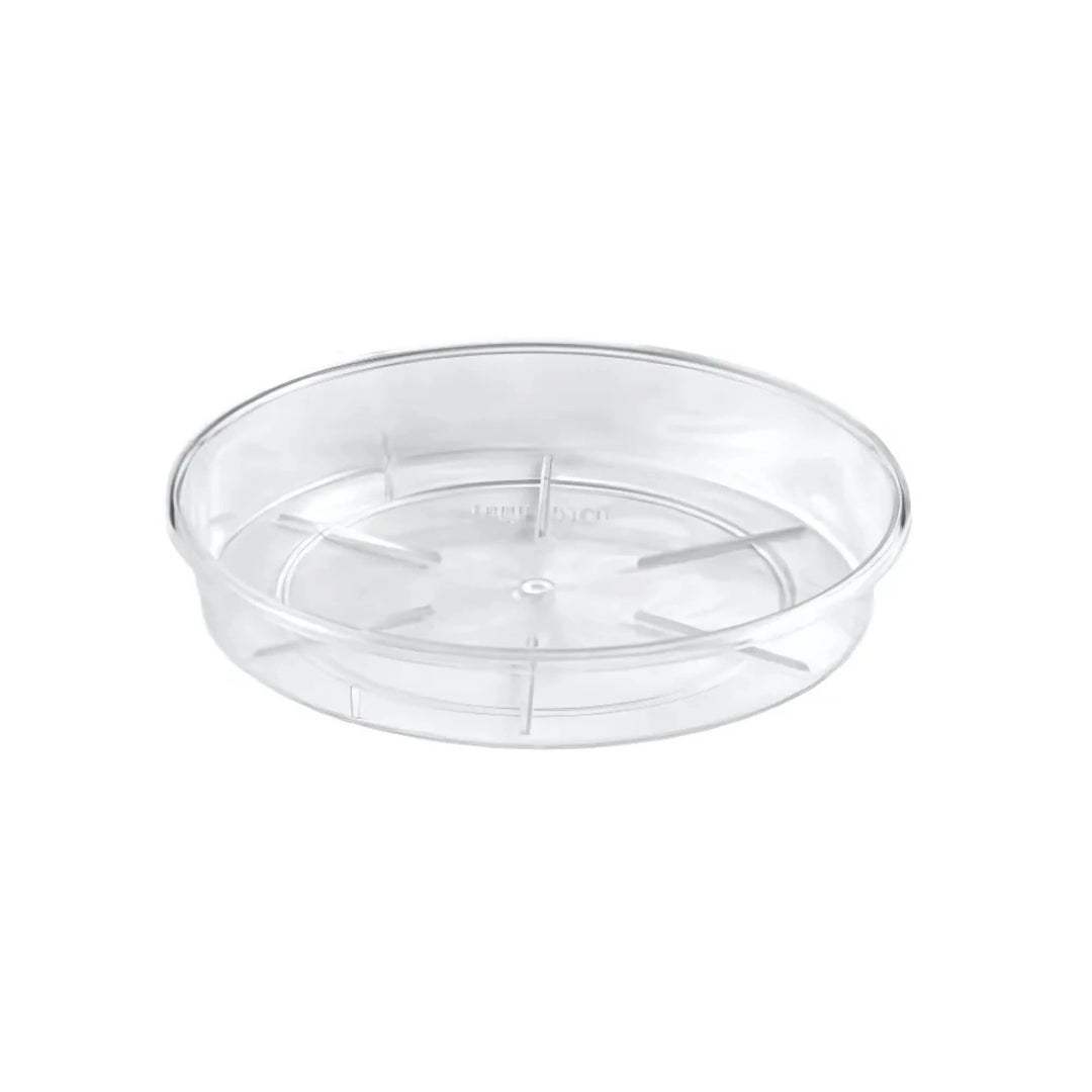 Sottovaso rotondo trasparente in plastica rigida, con base rialzata e scanalature interne per favorire il drenaggio dell'acqua. Ideale per vasi da interno.