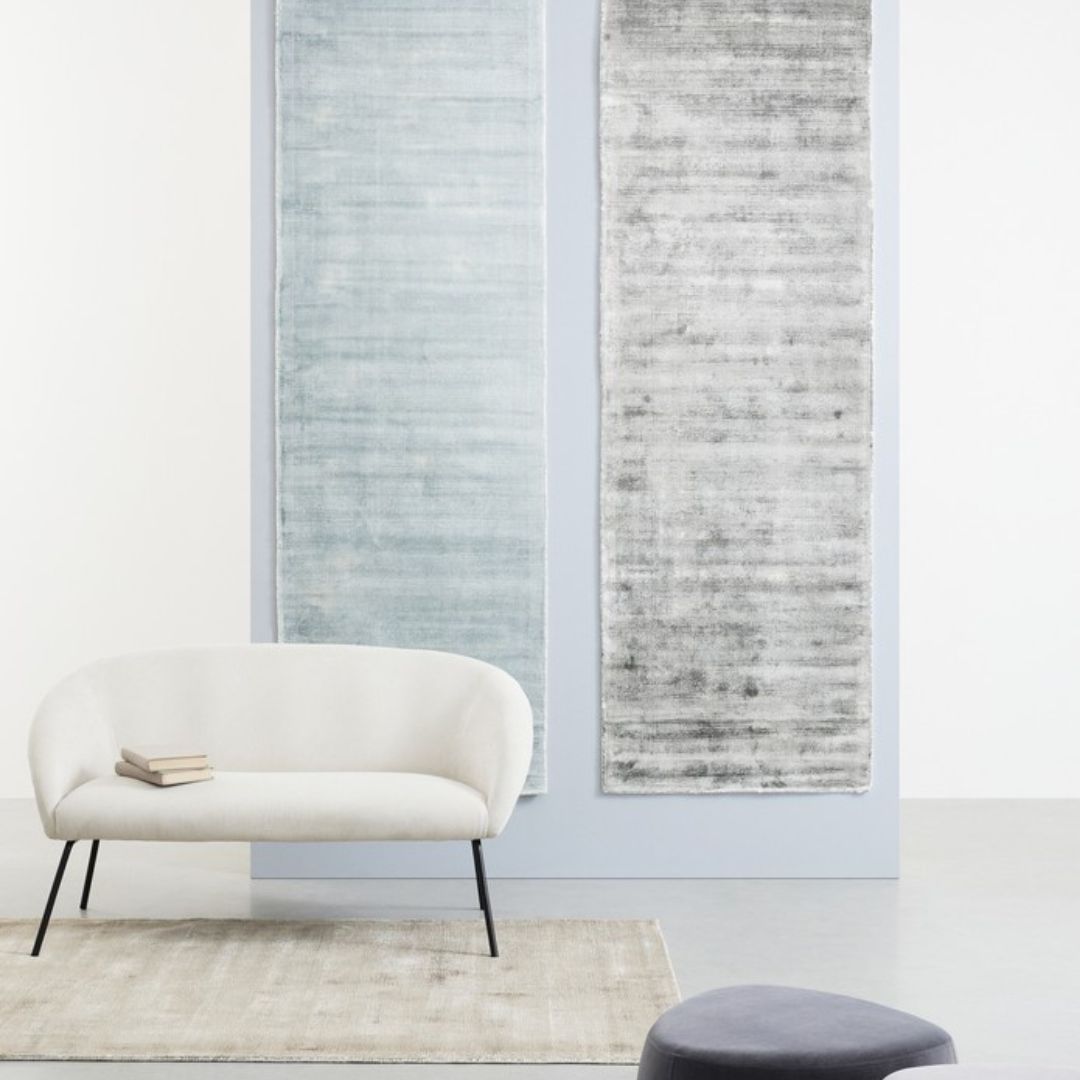 Tappeto Rashmi beige in ambientazione moderna con poltrona bianca
