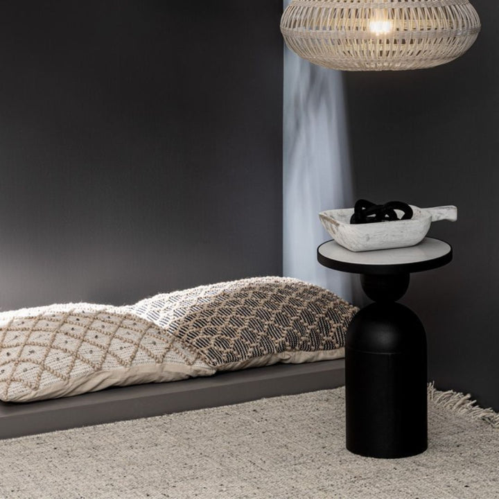 Tappeto con frange in stile boho posizionato in una zona relax con pareti scure