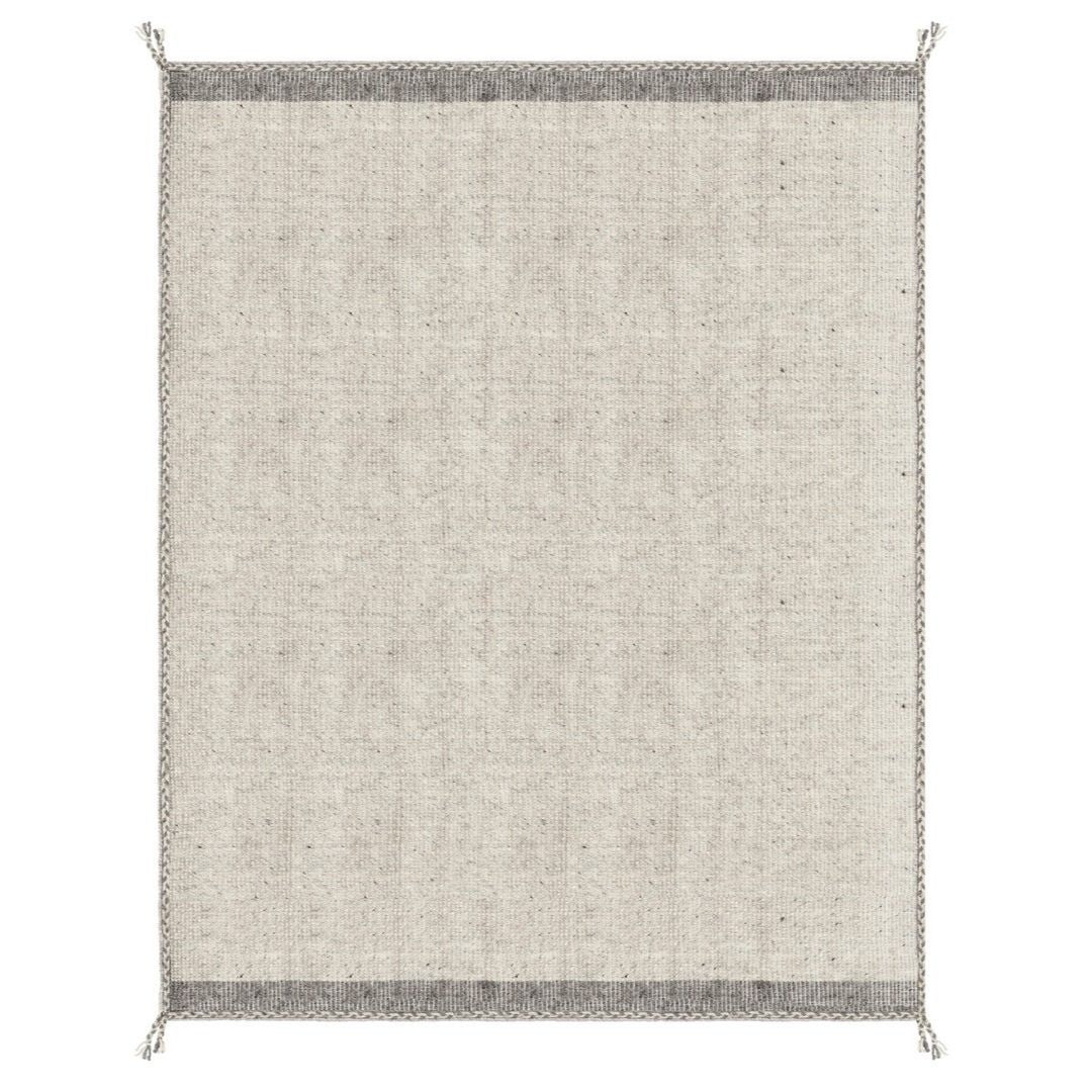 Tappeto Chathu beige in soggiorno moderno con libreria in legno

