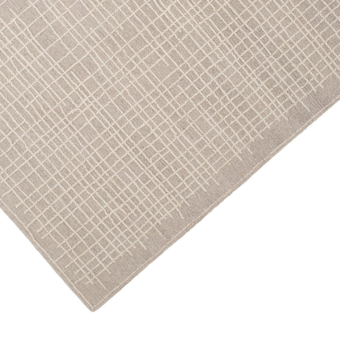 Dettaglio angolo tappeto grigio con linee a rilievo – superficie in rilievo stile moderno

