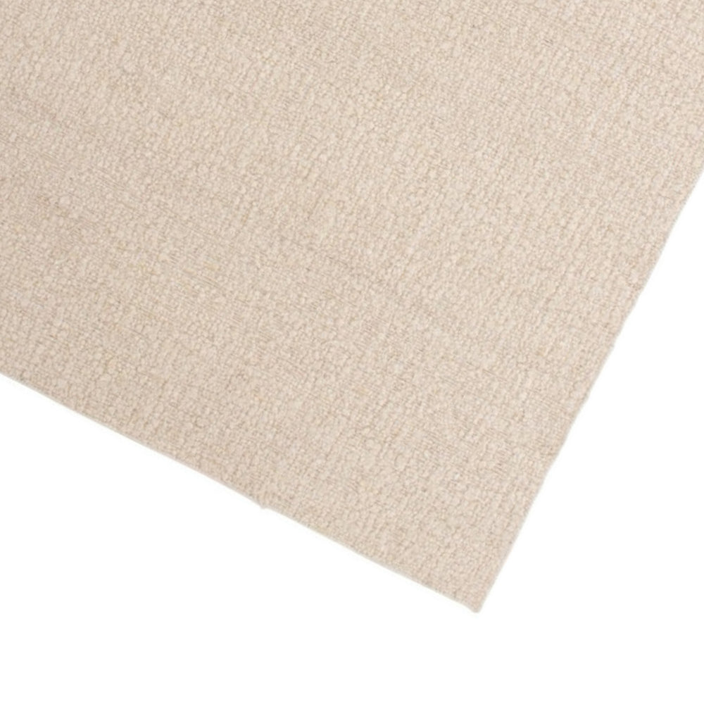 Dettaglio ravvicinato dell’angolo del tappeto in juta beige chiaro, che evidenzia la trama fitta e la lavorazione artigianale.