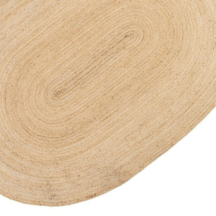 Dettaglio della trama intrecciata di un tappeto ovale in juta naturale, con lavorazione artigianale e finitura chiara.