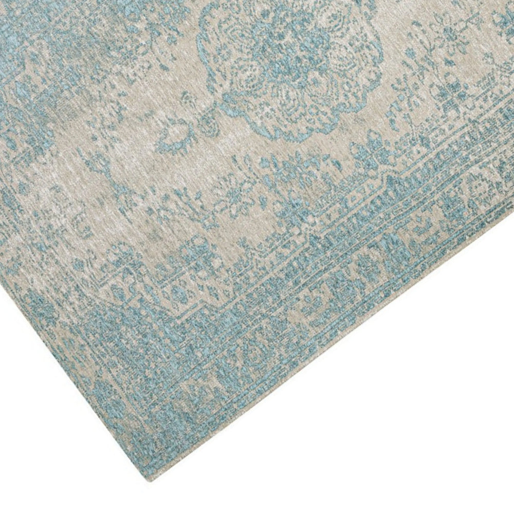 Dettaglio angolare del tappeto persiano azzurro con decori classici e texture vintage su base beige.