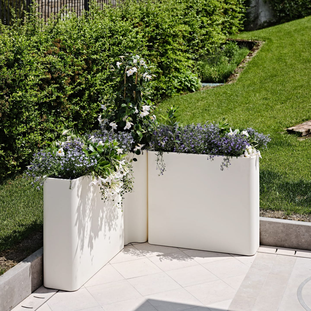 Fioriere angolari bianche con fiori da esterno.