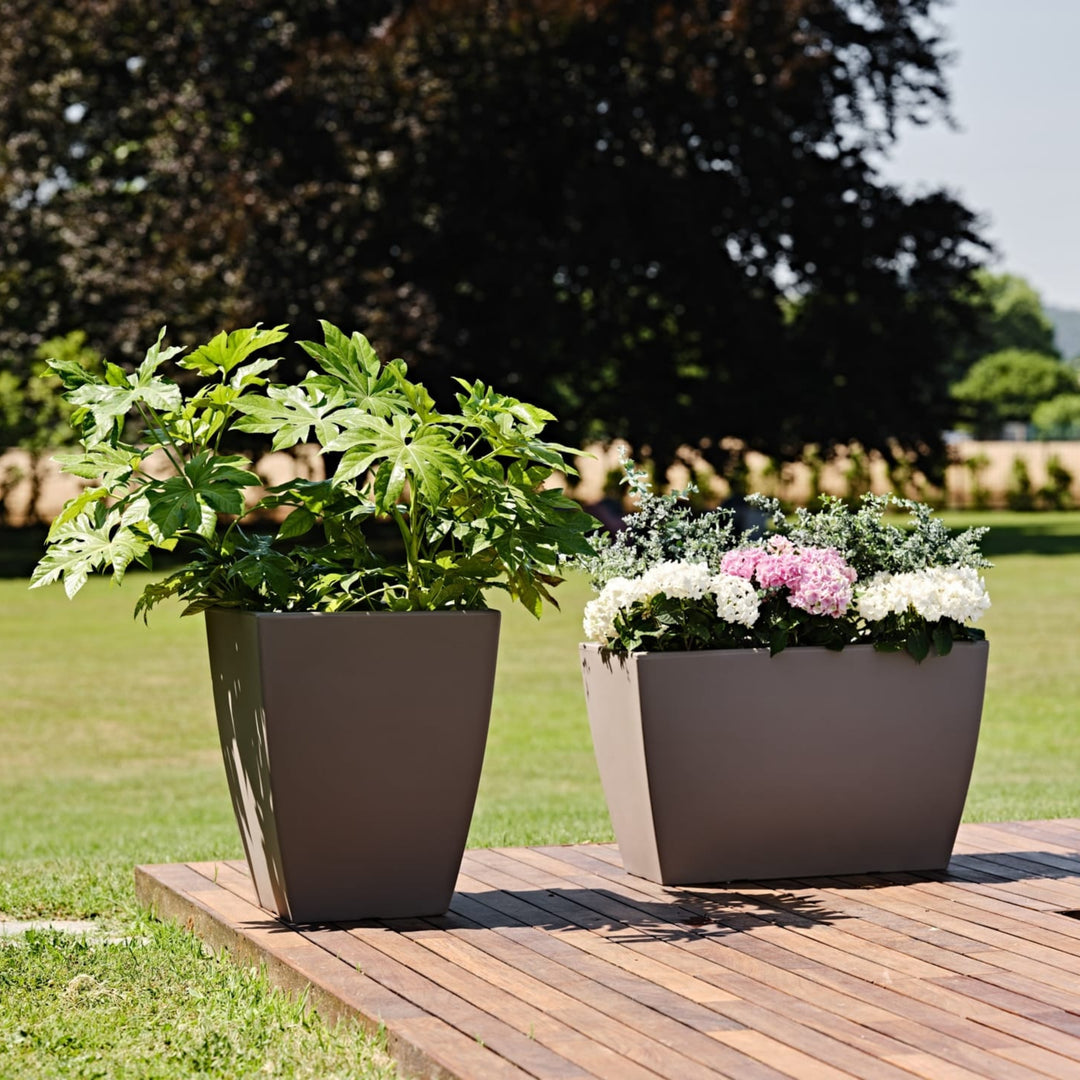 Fioriere moderne in resina con ortensie e piante verdi su pedana da giardino