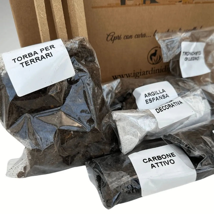 Dettaglio substrati inclusi nel Kit Terrarium Geometrico ADA: torba per terrari, carbone attivo, argilla espansa decorativa e tronchetto di legno in confezioni singole, con scatola brandizzata I Giardini di Giulia sullo sfondo.