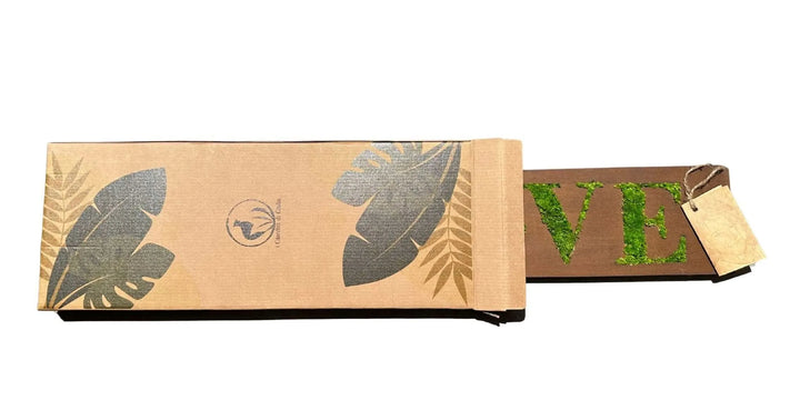 Packaging sostenibile con logo I Giardini di Giulia e quadro in muschio stabilizzato con scritta Love parzialmente visibile