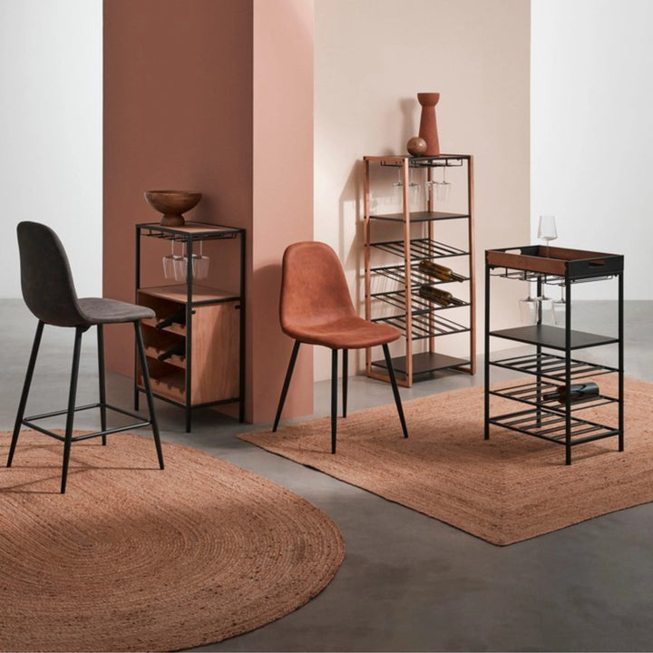 Ambientazione moderna con tappeti in juta color terracotta, arredi in metallo nero e legno, sedie imbottite e mobile porta vini dallo stile industriale.

