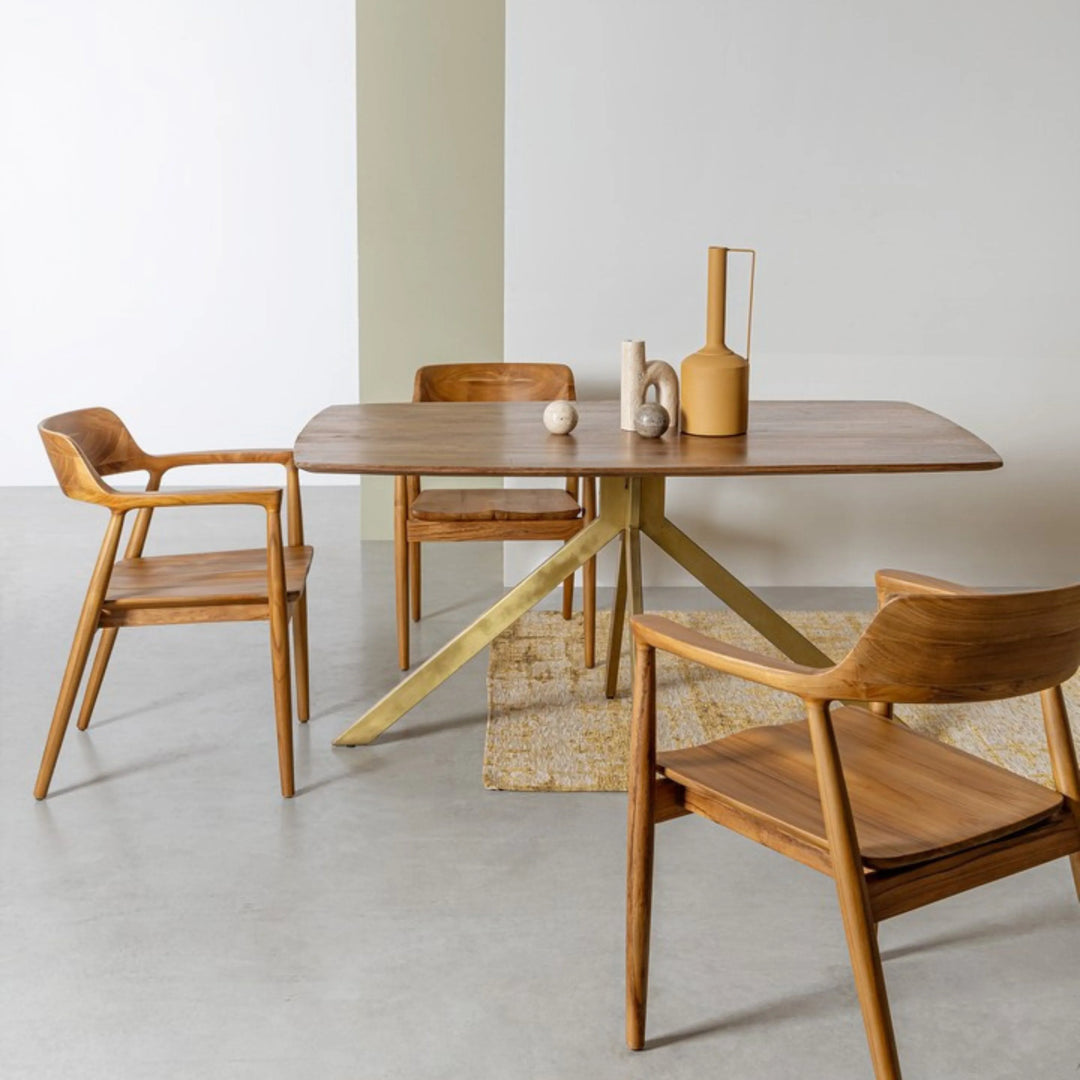 Tappeto moderno con motivo astratto in viscosa color senape, posizionato sotto un tavolo da pranzo in legno in un ambiente minimalista.