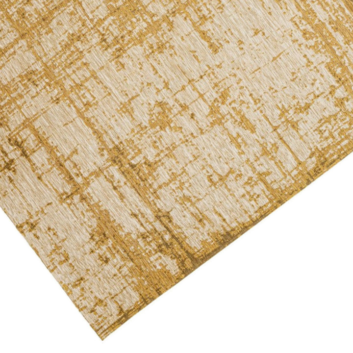 Dettaglio angolare di un tappeto in viscosa con design astratto color senape.