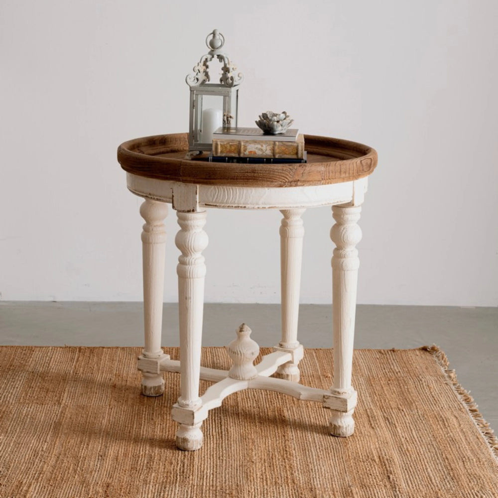 Tappeto in juta naturale con frange, ambientato con tavolino vintage in legno bianco e decorazioni d’arredo.