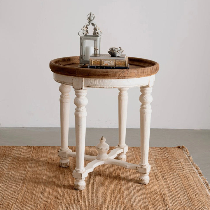 Tappeto in juta naturale con frange, ambientato con tavolino vintage in legno bianco e decorazioni d’arredo.