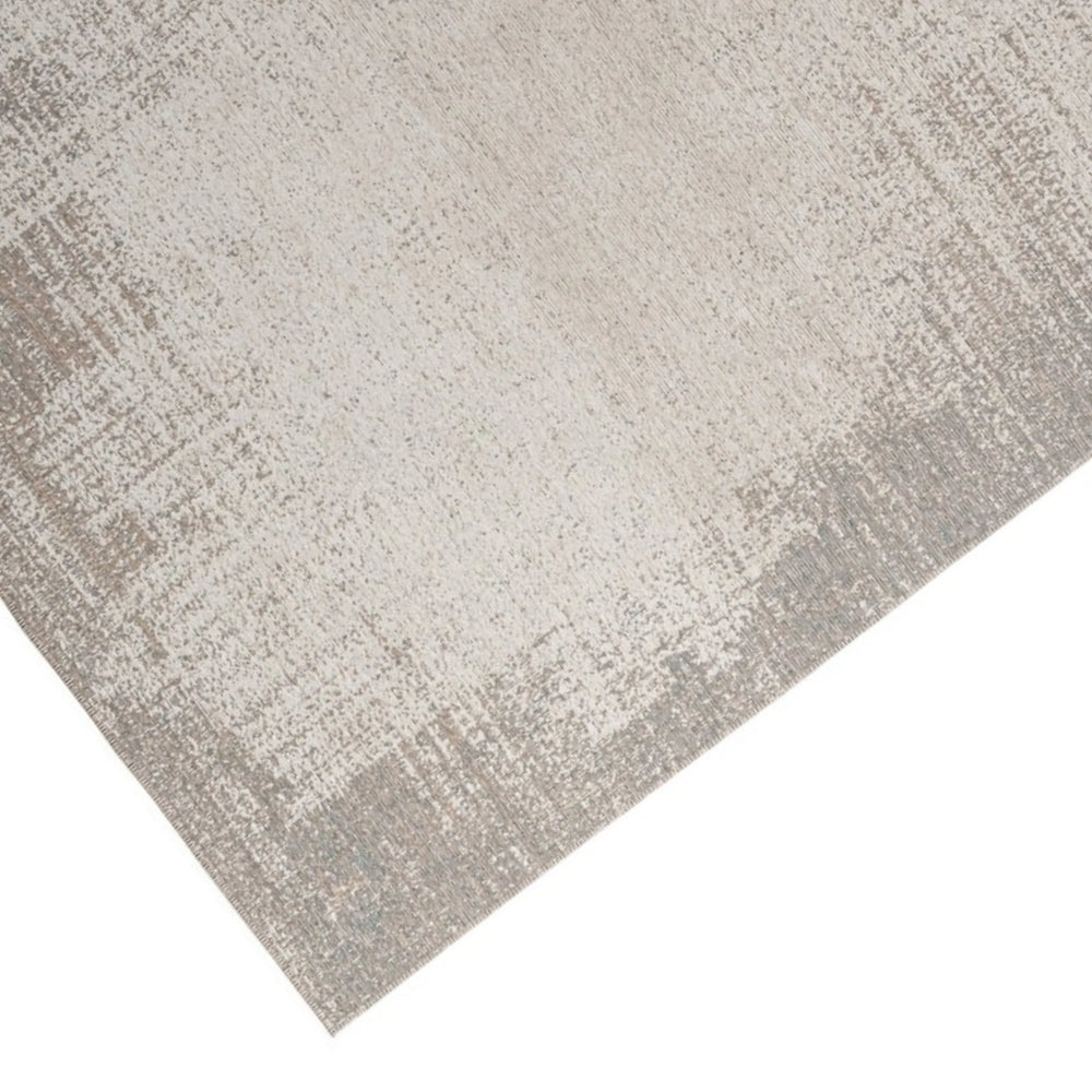 Zoom sul bordo del tappeto sfumato grigio, con trama elegante e tonalità neutre