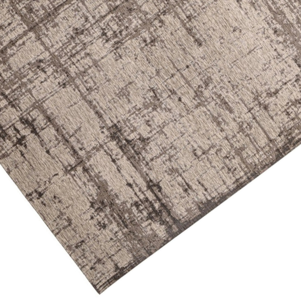 Dettaglio dell'angolo del tappeto moderno beige e marrone con motivo vissuto, tessitura a rilievo e finiture curate.