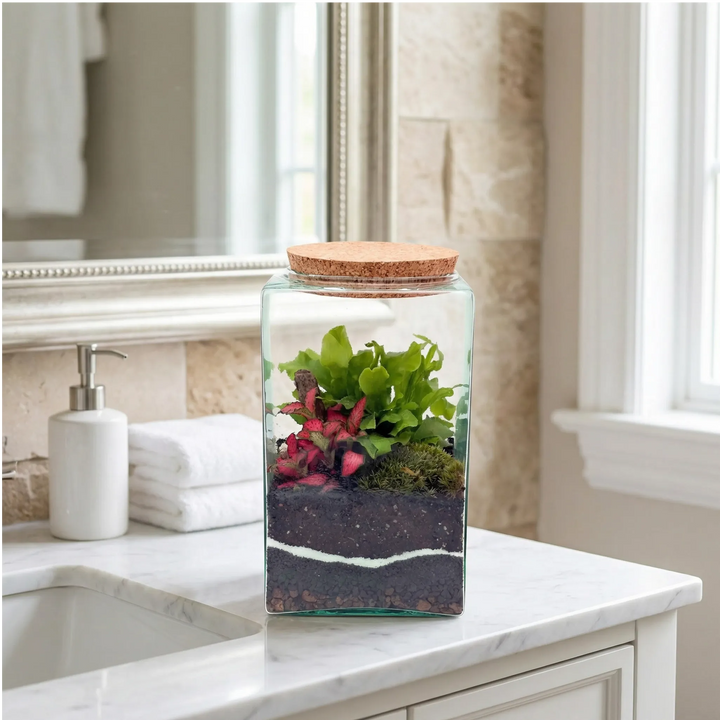 Terrarium elegante su mobile bagno marmo bianco con specchio e asciugamani