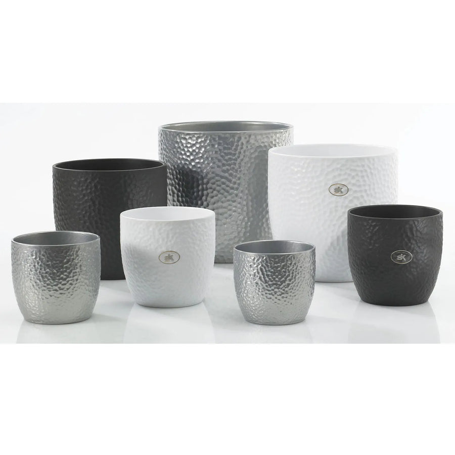 Collezione di vasi decorativi tondi in ceramica modello Boston, finitura martellata nei colori bianco, nero e argento, disposti su superficie chiara per presentazione.