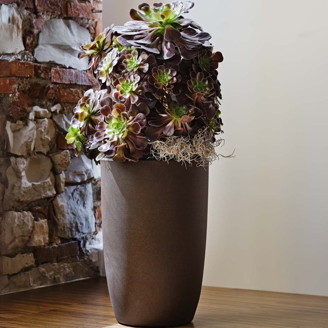 Vaso alto elegante in plastica effetto pietra con composizione di succulente viola e verdi, perfetto per arredamento da interno raffinato.